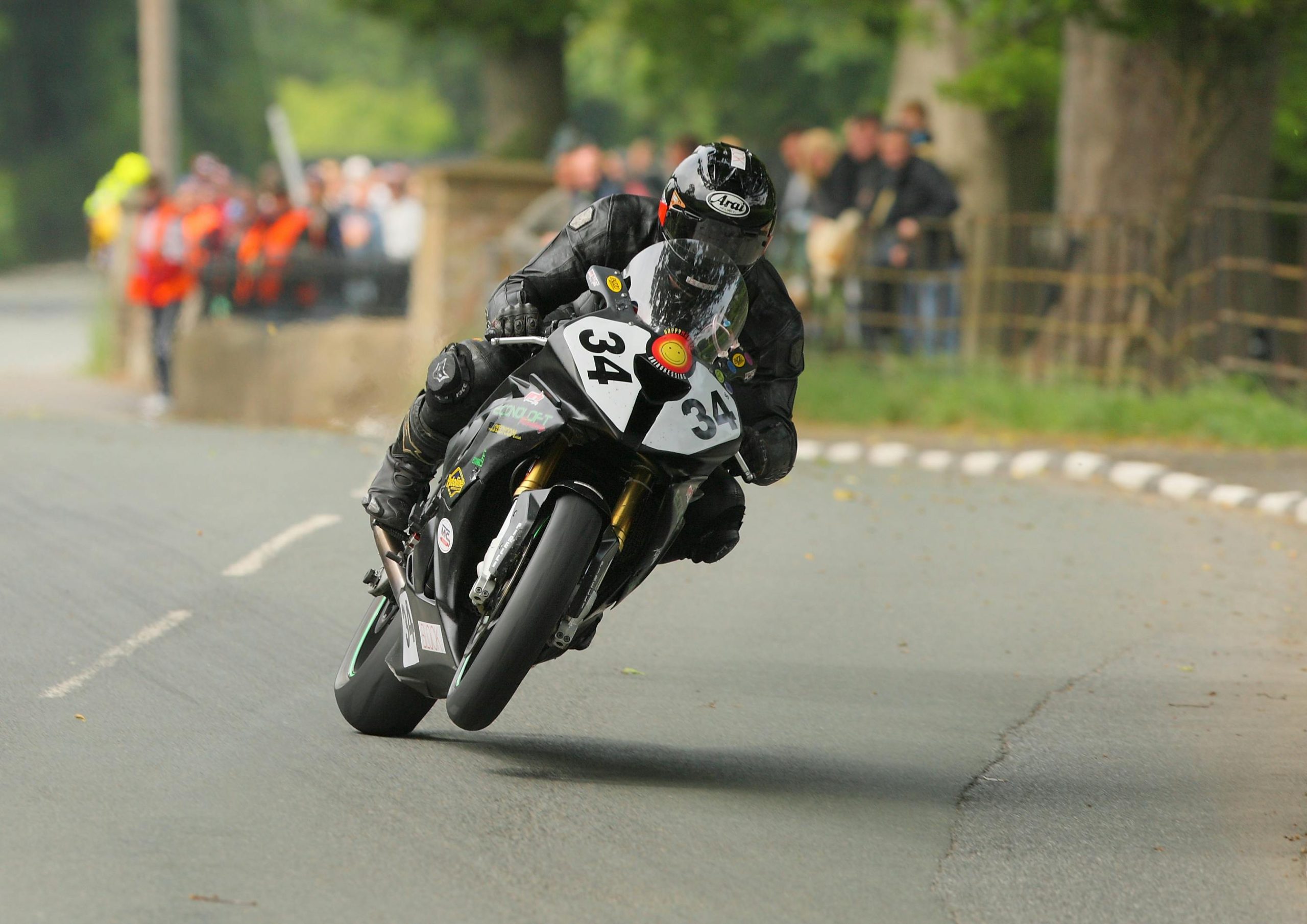 High-speed motorcycle racing action captured at the Isle of Man TT, showcasing daring sportsmanship.